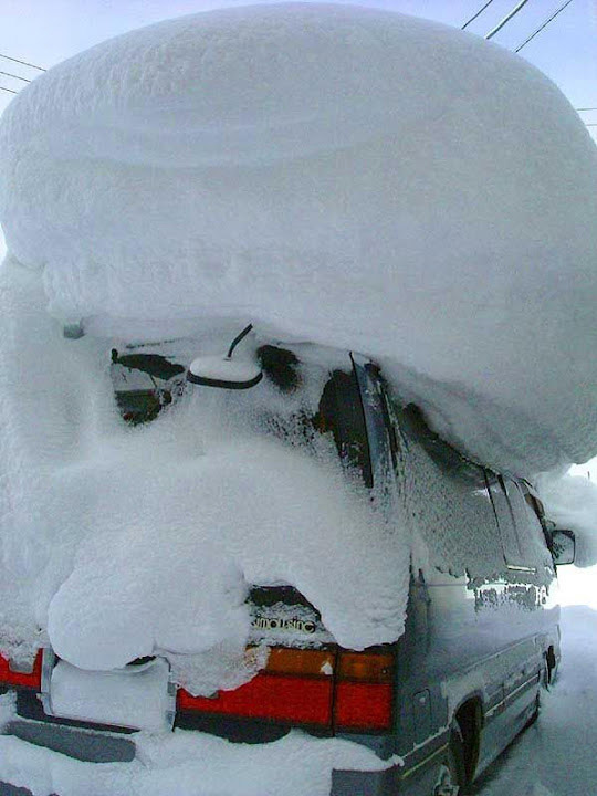 Car with huge pile of snow on roof